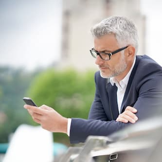 Grauhaariger Mann nutzt sein Smartphone