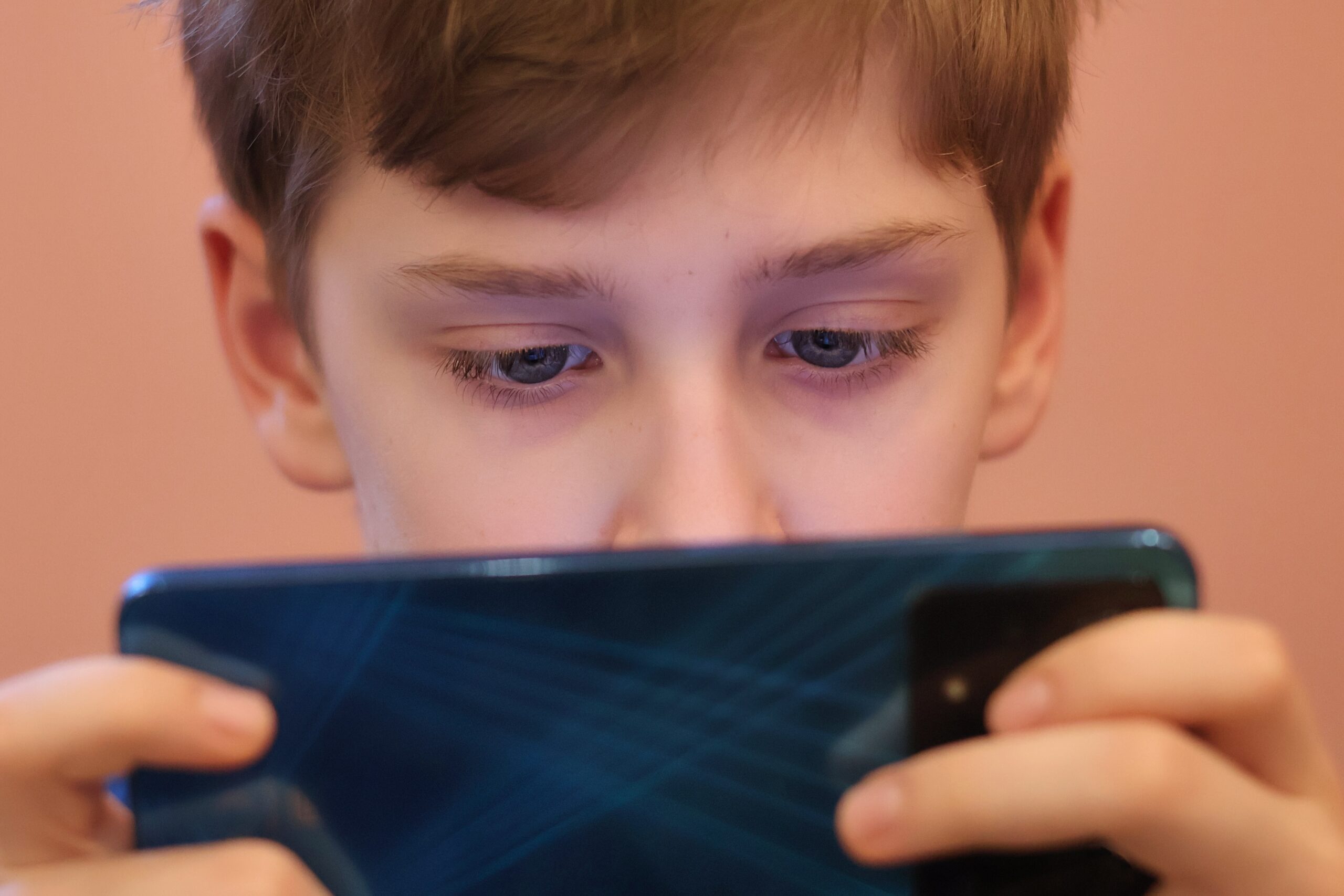 Close-up of a teenager’s eyes staring at a smartphone
